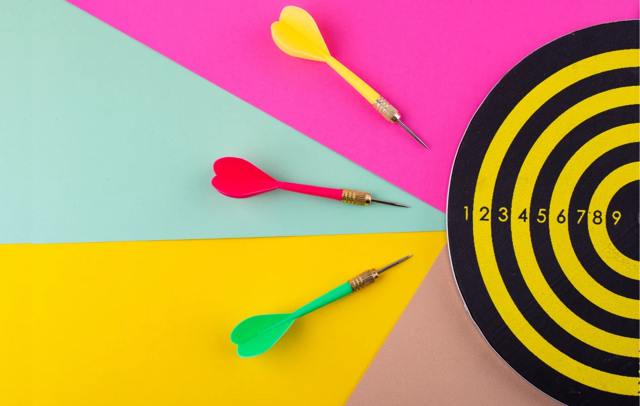 A Dart Board and Three Colorful Arrows in front of it