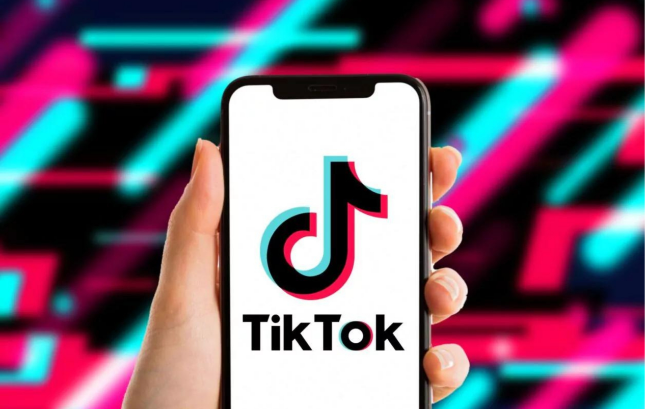 A Mobile Phone Holding by a Hand is Showing TikTok Logo
